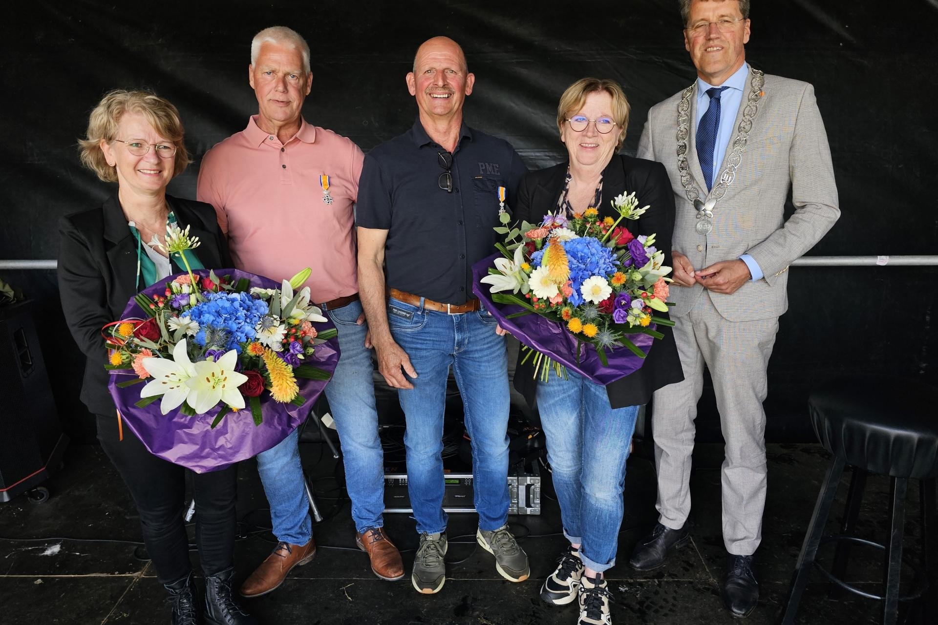Jan Gommer en Klaas Duursma met twee dames en burgemeester Eric van Oosterhout tijdens uitreiking van Koninklijke Onderscheiding