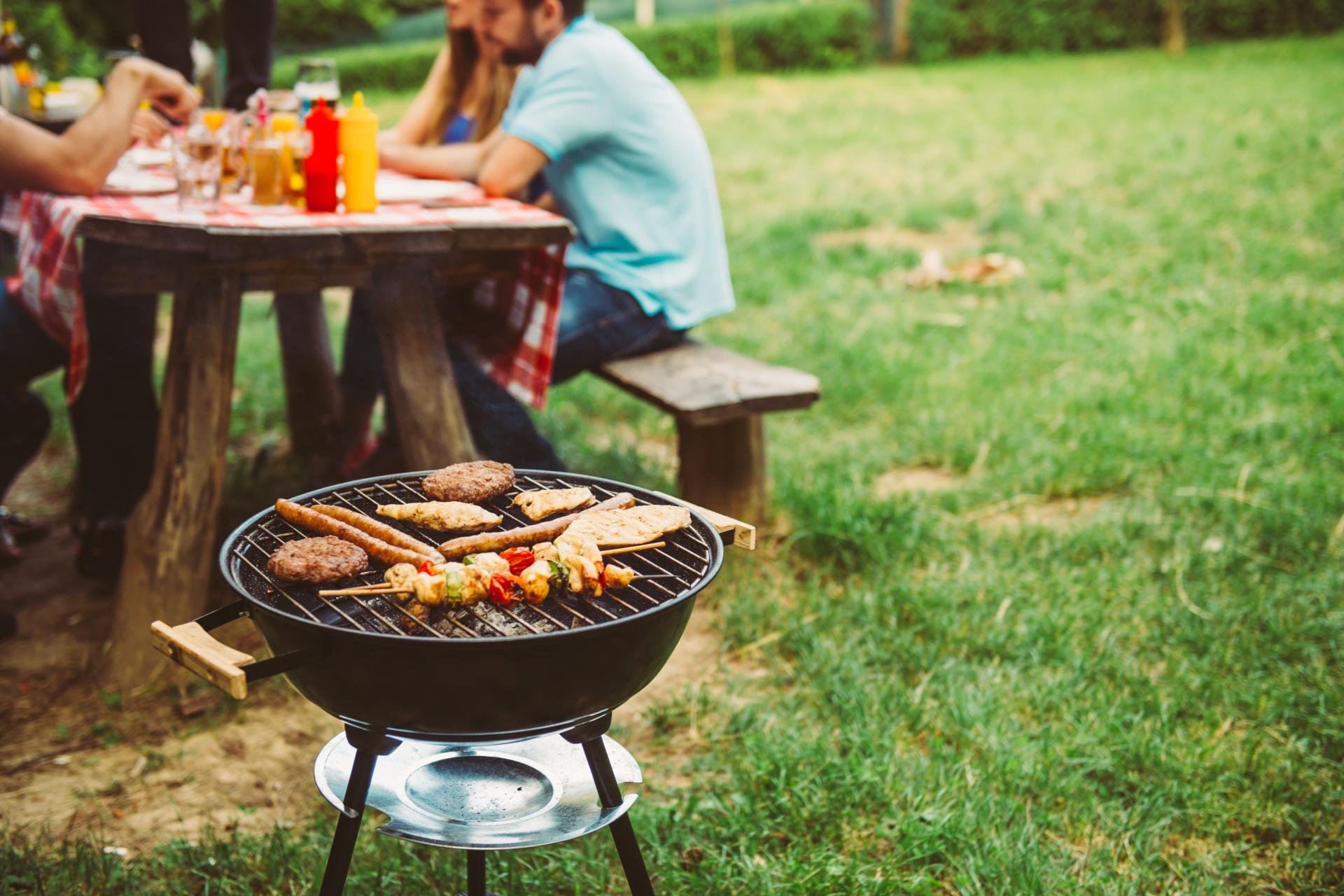 Dorpsfeest met barbecue en mensen in een tuin aan tafel