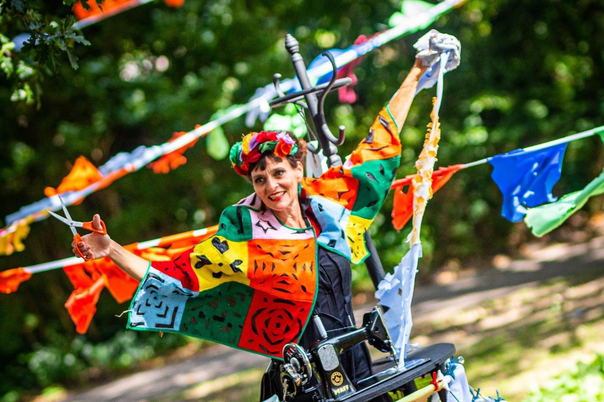 Mevrouw met gekleurde kleding en slingers tijdens het UITfestival
