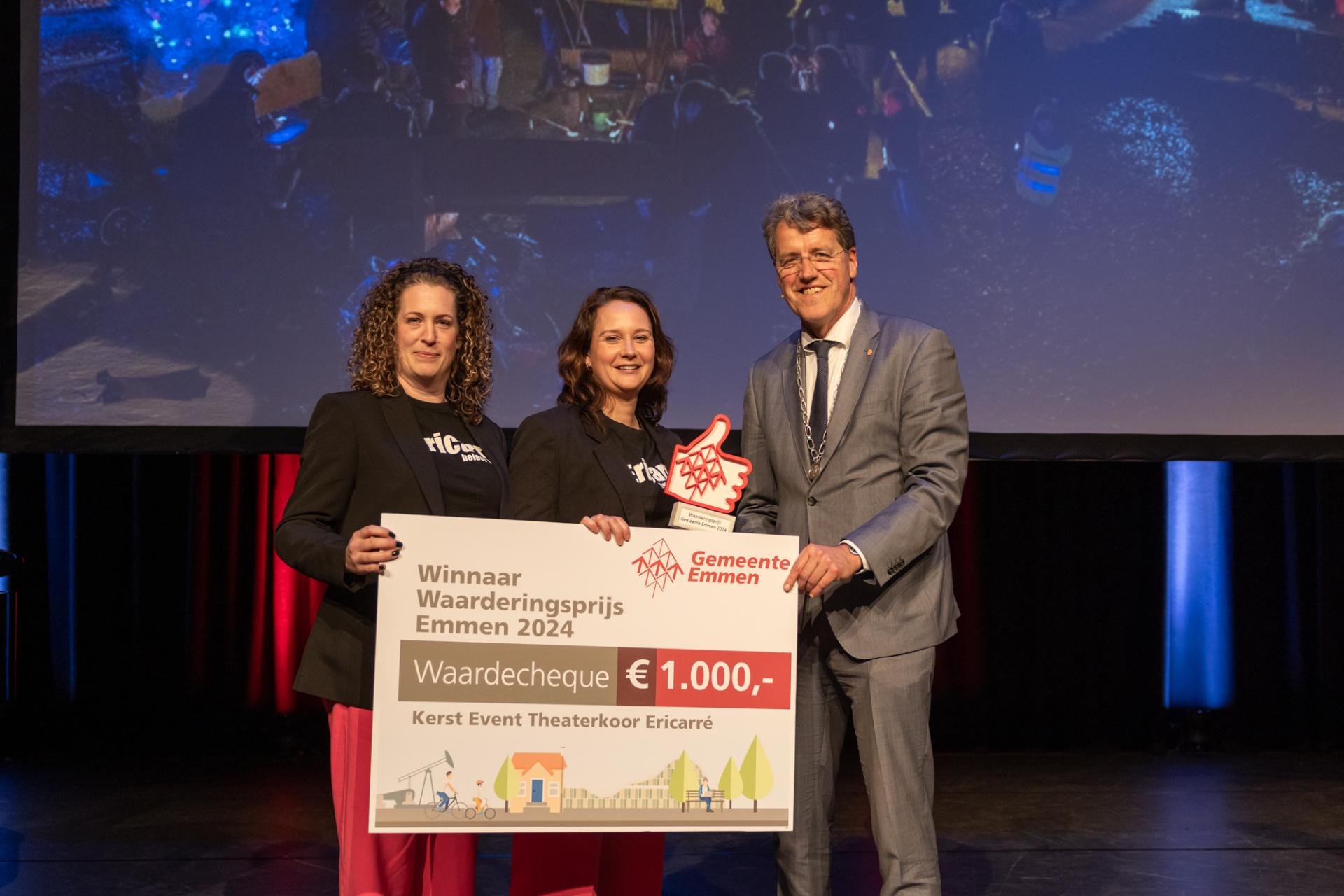 Twee dames van Erricarré samen met burgemeester Eric van Oosterhout houden een cheque van 1000 euro vast.